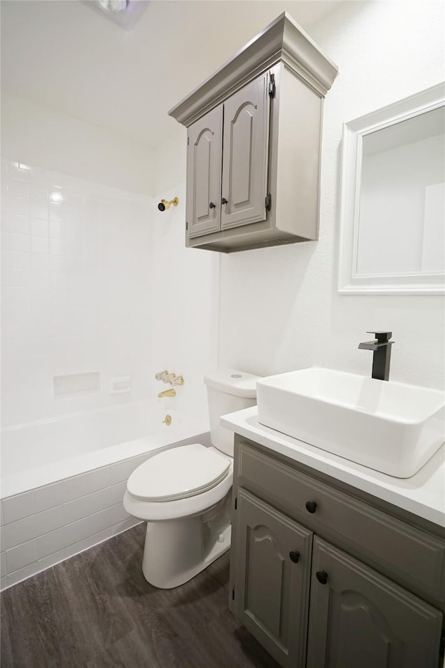 full bathroom featuring toilet, vanity, wood finished floors, and shower / bath combination