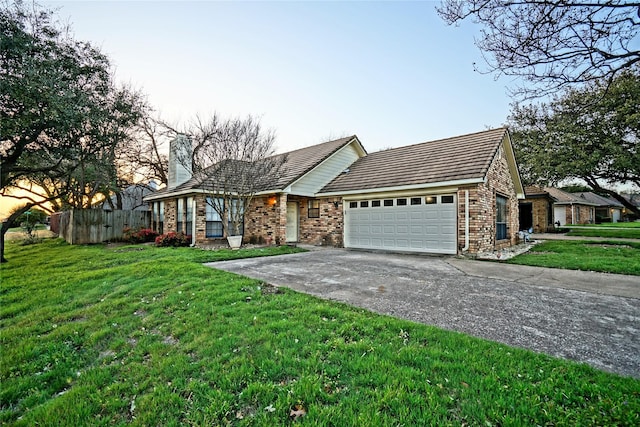 ranch-style home featuring a chimney, driveway, a front yard, and a garage