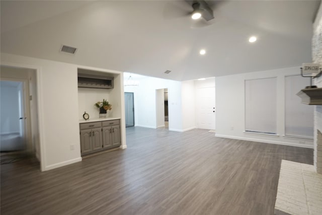 unfurnished living room with ceiling fan, vaulted ceiling, visible vents, and baseboards