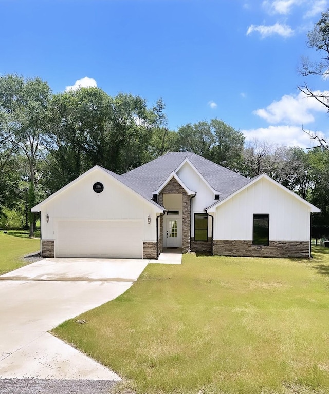 186 Vista Dr, Eustace, TX 75124 - view of front facade featuring a garage, driveway, stone siding, and a front lawn