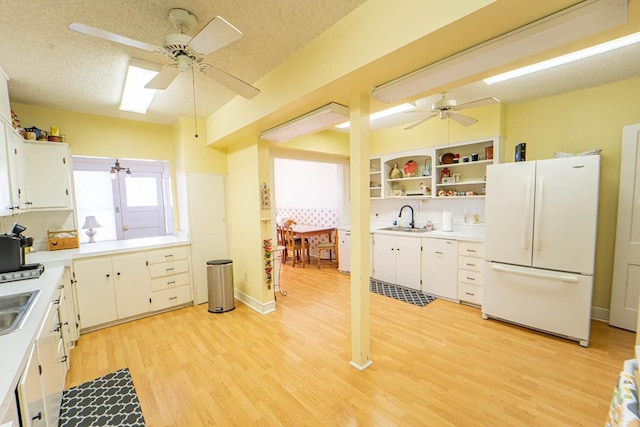 kitchen with light countertops, freestanding refrigerator, light wood-style floors, and ceiling fan