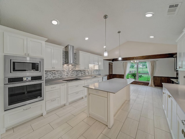 907 Red Oak Creek Dr, Ovilla, TX 75154 - kitchen with appliances with stainless steel finishes, wall chimney exhaust hood, lofted ceiling, a kitchen island, and tasteful backsplash