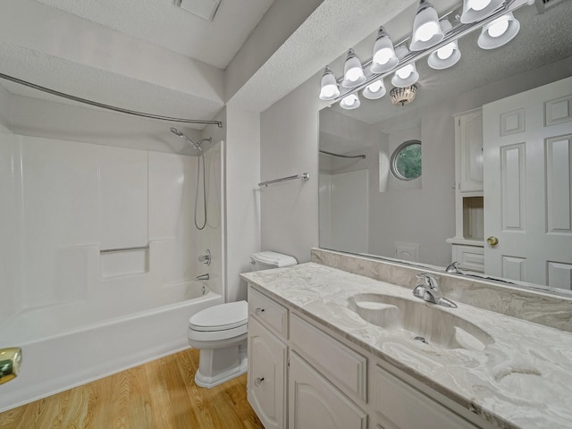 907 Red Oak Creek Dr, Ovilla, TX 75154 - bathroom featuring toilet, wood finished floors, shower / tub combination, vanity, and a textured ceiling
