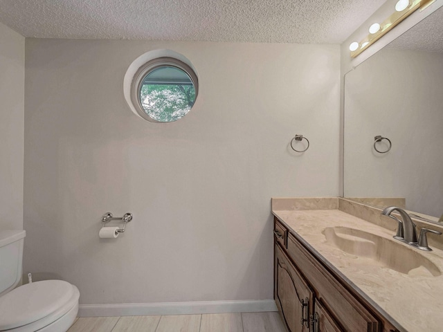 907 Red Oak Creek Dr, Ovilla, TX 75154 - bathroom with a textured ceiling, toilet, vanity, and baseboards