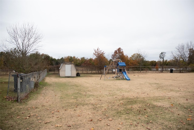 view of play area with a yard, an outbuilding, a shed, and a fenced backyard