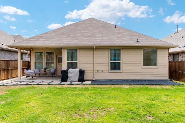 rear view of property featuring a yard, a fenced backyard, and a patio area
