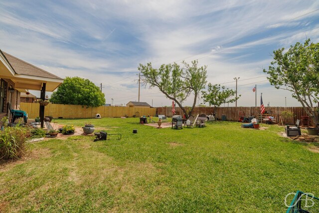 view of yard with a fenced backyard, a patio, and an outdoor fire pit