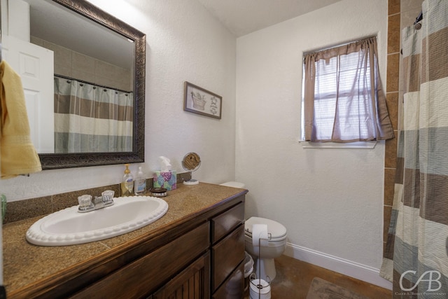full bath with vanity, a shower with curtain, a textured wall, baseboards, and toilet