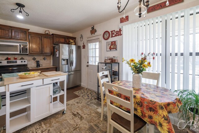 kitchen featuring decorative backsplash, open shelves, and stainless steel appliances
