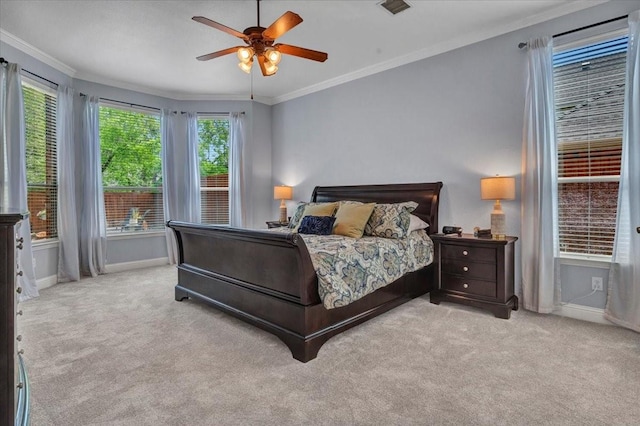 carpeted bedroom with ceiling fan, visible vents, baseboards, and ornamental molding