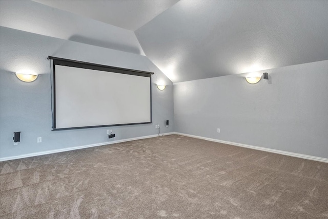 cinema with vaulted ceiling, baseboards, and carpet floors