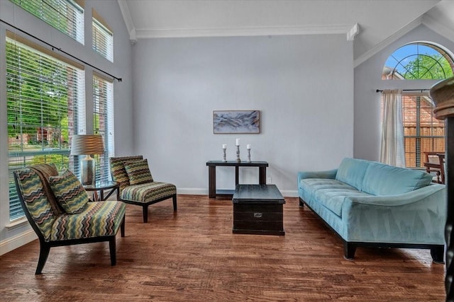 sitting room featuring baseboards, crown molding, and a healthy amount of sunlight