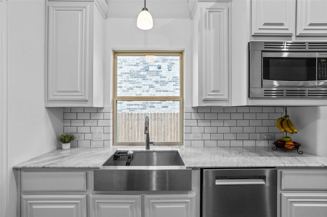 kitchen featuring white cabinets, stainless steel appliances, a sink, and tasteful backsplash