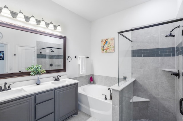 full bathroom featuring double vanity, a shower stall, a garden tub, and a sink