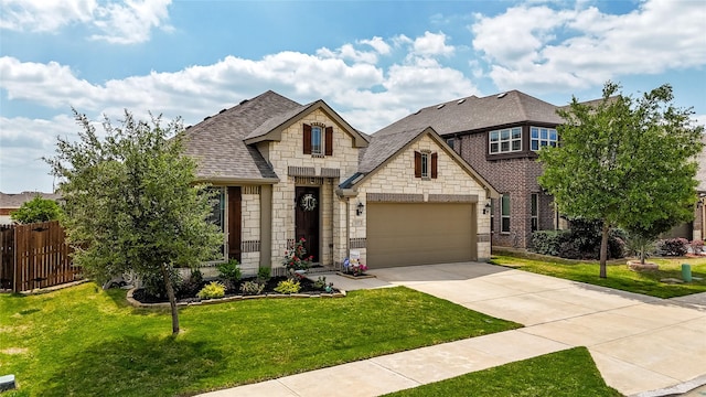 french country home with fence, an attached garage, driveway, stone siding, and a front yard