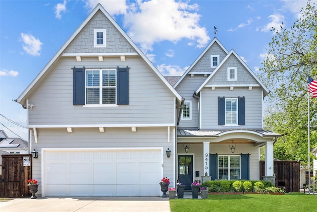 craftsman inspired home with driveway, covered porch, fence, a front yard, and a garage