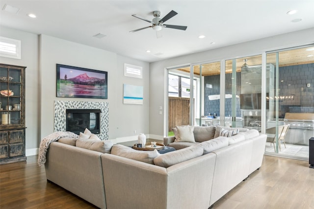 living area with wood finished floors, a fireplace, recessed lighting, and ceiling fan