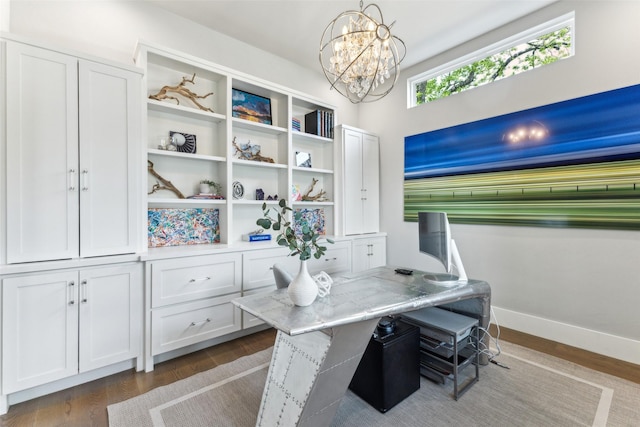 office area with dark wood finished floors, an inviting chandelier, and baseboards