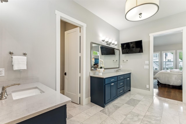 full bath with two vanities, ensuite bath, marble finish floor, and a sink