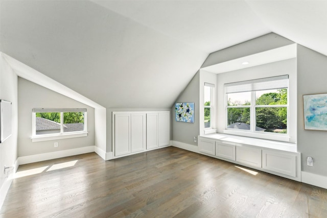 bonus room with vaulted ceiling, wood finished floors, and baseboards