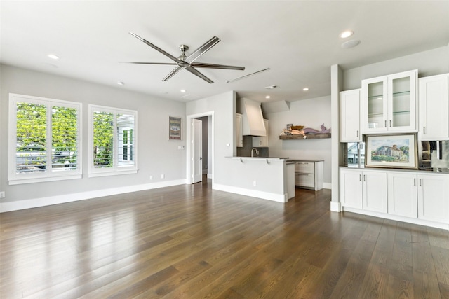 unfurnished living room featuring recessed lighting, a ceiling fan, a sink, dark wood-type flooring, and baseboards