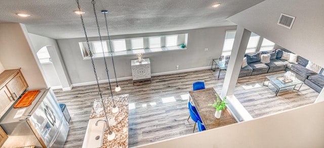 1023 Clydeview Rd, Forney, TX 75126 - living area featuring baseboards, wood finished floors, visible vents, and a textured ceiling