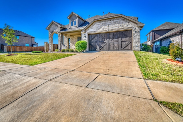 1023 Clydeview Rd, Forney, TX 75126 - view of front facade featuring concrete driveway, stone siding, fence, a front yard, and a garage