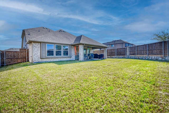 1023 Clydeview Rd, Forney, TX 75126 - rear view of house with a fenced backyard, roof with shingles, brick siding, and a yard
