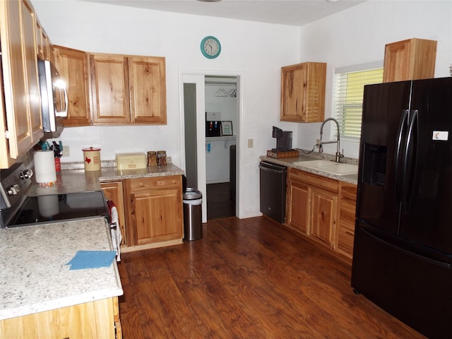 kitchen featuring a sink, black appliances, brown cabinets, light countertops, and dark wood-style floors