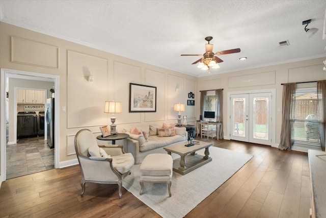 living room with a decorative wall, crown molding, and ceiling fan