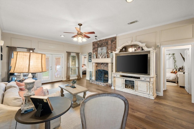 living room with wood finished floors, ceiling fan, and crown molding