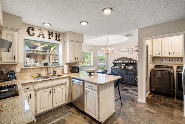 kitchen featuring a sink, separate washer and dryer, dishwasher, a peninsula, and a notable chandelier