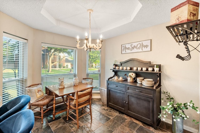 dining area with plenty of natural light, a textured ceiling, stone finish flooring, and an inviting chandelier