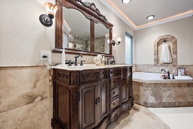 bathroom featuring tile patterned flooring, double vanity, a textured wall, ornamental molding, and a bath