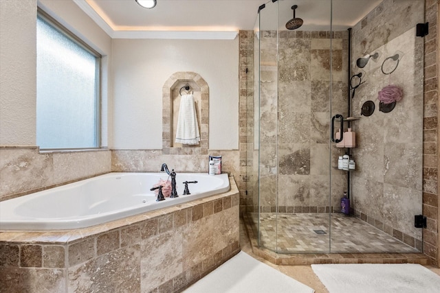 full bathroom with a bath and a stall shower