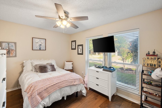 bedroom featuring wood finished floors, a textured ceiling, a ceiling fan, and baseboards