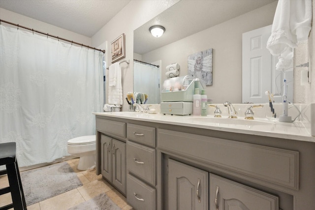 full bathroom featuring tile patterned flooring, double vanity, toilet, a sink, and a textured ceiling