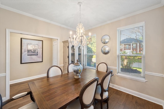 dining room featuring dark wood finished floors, an inviting chandelier, ornamental molding, and baseboards