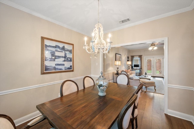 dining room featuring baseboards, visible vents, ceiling fan with notable chandelier, crown molding, and wood-type flooring