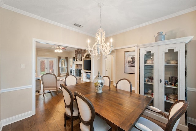 dining room featuring dark wood finished floors, visible vents, crown molding, baseboards, and a notable chandelier