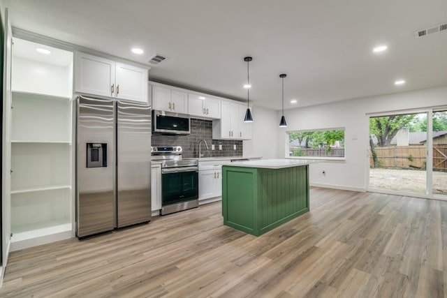 237 Trailridge Dr, Garland, TX 75043 - kitchen featuring light wood-style floors, a center island, visible vents, and appliances with stainless steel finishes