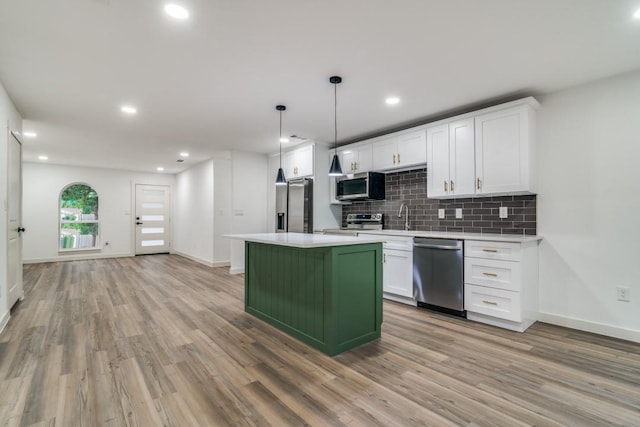 237 Trailridge Dr, Garland, TX 75043 - kitchen featuring stainless steel appliances, light wood-type flooring, tasteful backsplash, white cabinetry, and recessed lighting