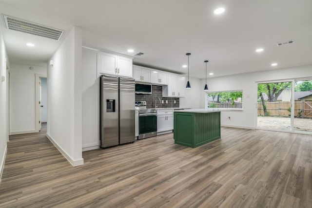 237 Trailridge Dr, Garland, TX 75043 - kitchen with a kitchen island, stainless steel appliances, baseboards, and visible vents