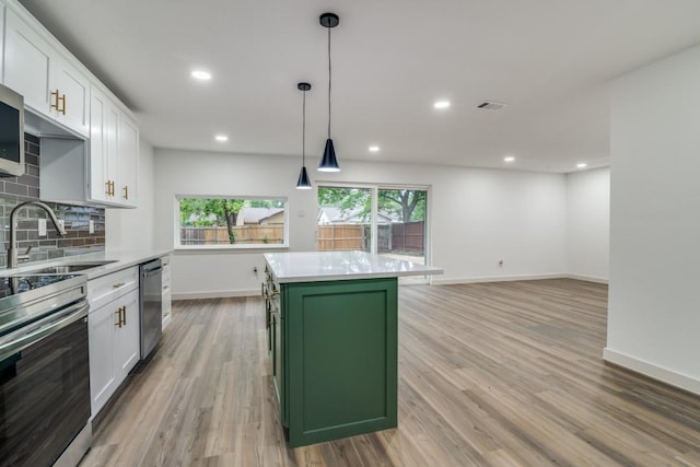 237 Trailridge Dr, Garland, TX 75043 - kitchen with a sink, green cabinetry, baseboards, white cabinetry, and light wood-style flooring