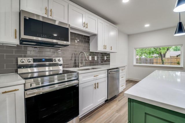 237 Trailridge Dr, Garland, TX 75043 - kitchen featuring decorative backsplash, light wood-type flooring, light countertops, a sink, and stainless steel appliances