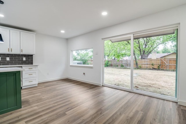 237 Trailridge Dr, Garland, TX 75043 - kitchen featuring light wood-style floors, light countertops, baseboards, and backsplash