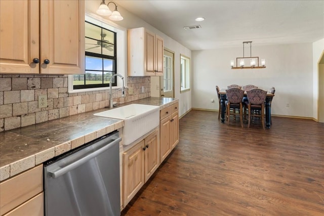 kitchen with dark wood finished floors, an inviting chandelier, dishwasher, visible vents, and a sink