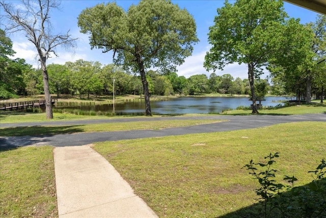 view of community with a lawn and a water view