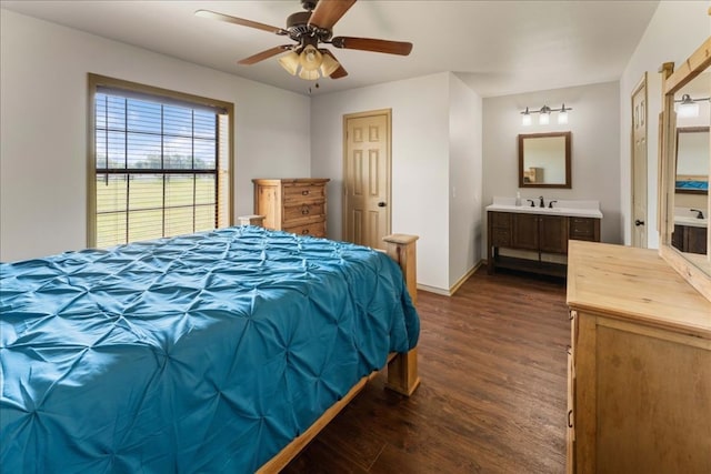 bedroom with dark wood-style floors, a ceiling fan, a sink, connected bathroom, and baseboards