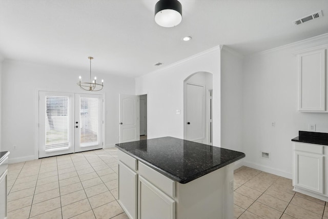 924 Charleston Ln, Savannah, TX 76227 - kitchen with white cabinets, visible vents, light tile patterned flooring, arched walkways, and a center island